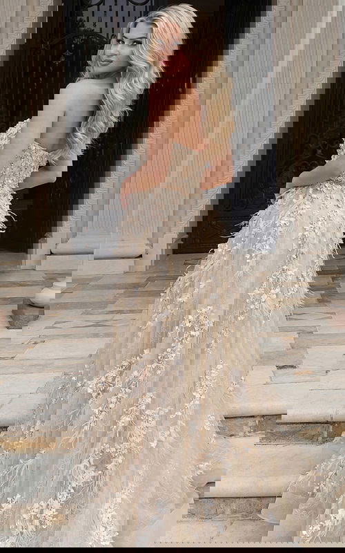 Back view of a strapless gown with floral appliqué and flowing tulle skirt