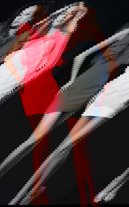 Models wearing elegant mini dresses, one in red with dramatic ruffles and the other in white featuring a large organza flower design