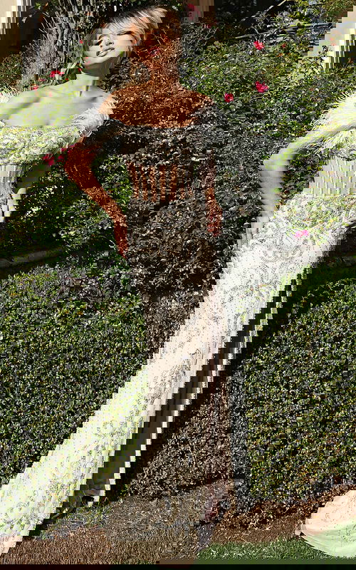 Model wearing sheer corset gown with beaded pattern and side slit